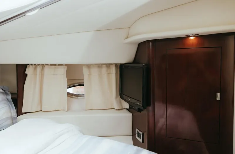 Slide: The Image of Interior cabin of 2010 Sea Ray 390 Sedan Bridge with bed, window, and TV. - 19