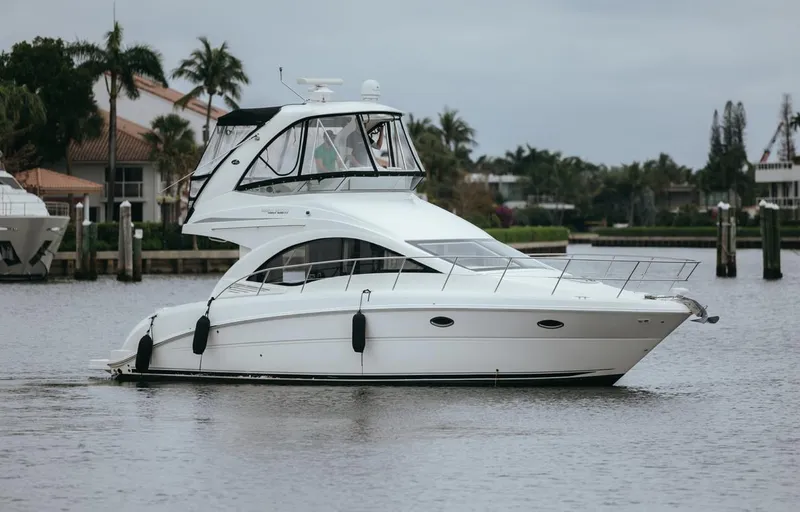Slide: The Image of 2010 Sea Ray 390 Sedan Bridge yacht cruising on a calm waterway. - 2