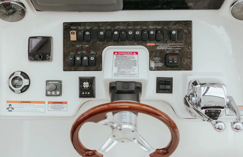 Slide: The Image of Control panel of a 2010 Sea Ray 390 Sedan Bridge with steering wheel and switches. - 21