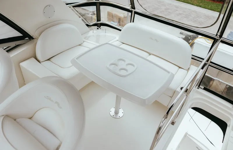 Slide: The Image of Interior of 2010 Sea Ray 390 Sedan Bridge with white seating and table. - 24