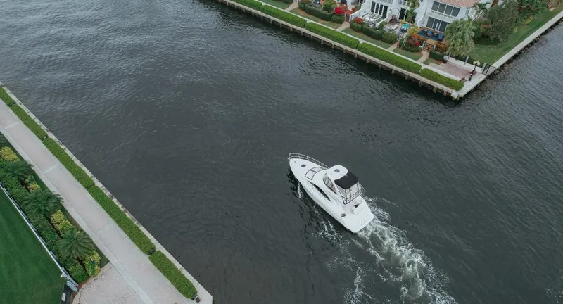 Slide: The Image of Aerial view of 2010 Sea Ray 390 Sedan Bridge cruising near waterfront homes. - 9