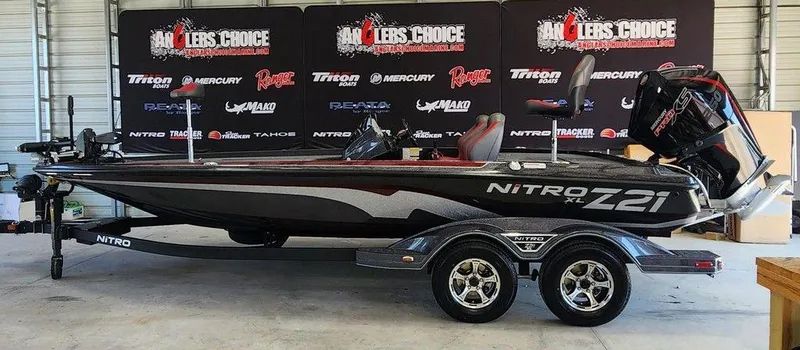 The Image of 2026 Nitro Z21 XL Pro boat in showroom with promotional banners in background. - 1