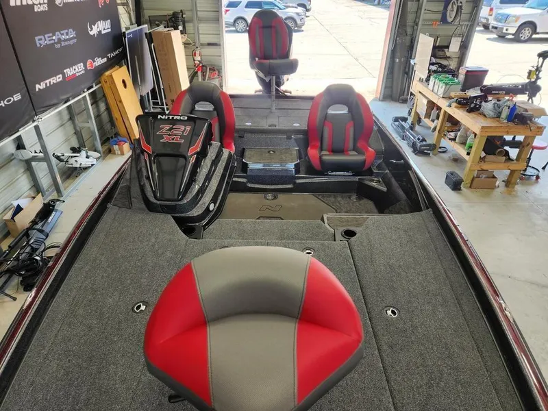Slide: The Image of 2026 Nitro Z21 XL Pro boat interior with red and gray seating in a workshop. - 11