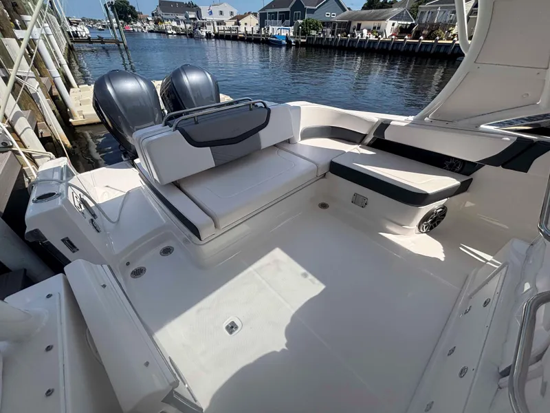 Slide: The Image of 2020 Chaparral 300 OSX boat interior with seating, docked by waterfront homes. - 17