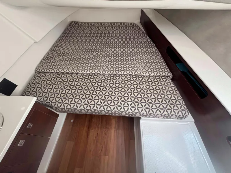 Slide: The Image of 2020 Chaparral 300 OSX cabin interior with patterned bedding and wooden flooring. - 21