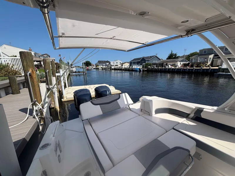 Slide: The Image of 2020 Chaparral 300 OSX boat docked by waterfront homes under clear blue sky. - 29