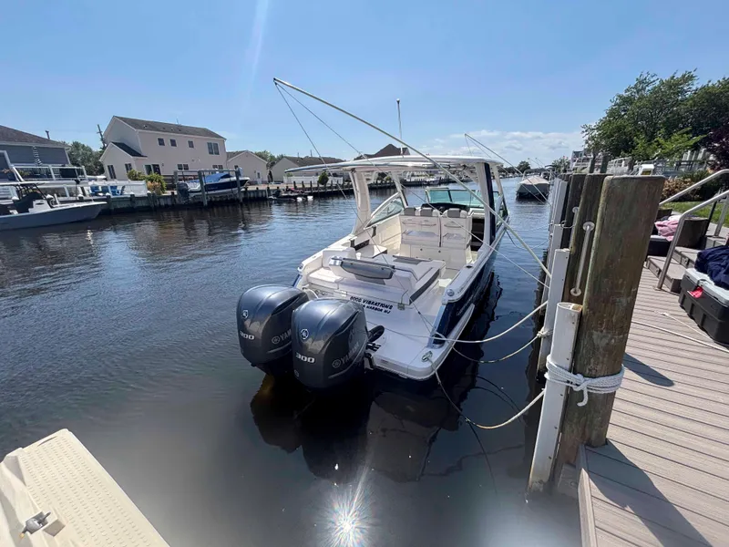 Slide: The Image of 2020 Chaparral 300 OSX boat docked with dual Yamaha engines in a residential marina. - 30