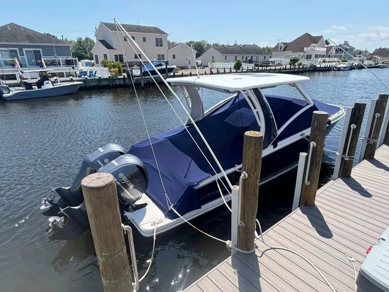 Slide: The Image of 2020 Chaparral 300 OSX boat docked with blue cover and twin Yamaha engines. - 5