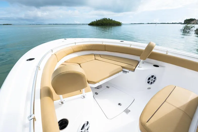 Slide: The Image of 2025 Sportsman Heritage 231 boat interior with tan seating, on calm water. - 11