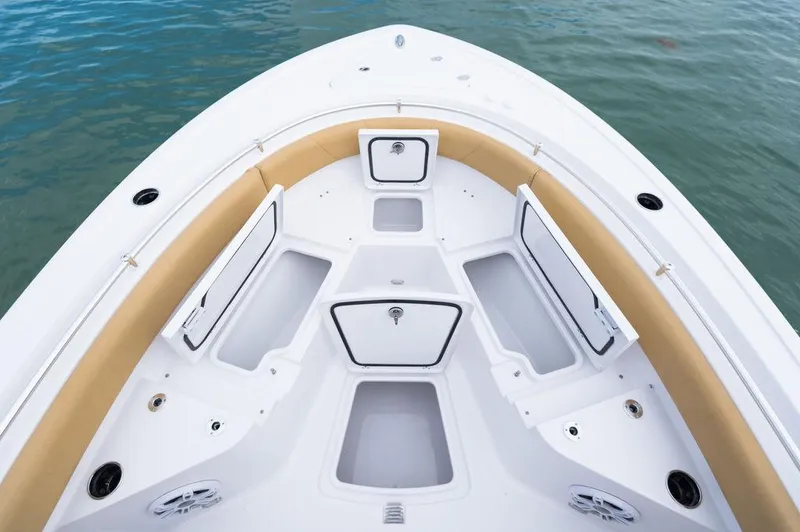 Slide: The Image of 2025 Sportsman Heritage 231 boat interior with open storage compartments on calm water. - 15