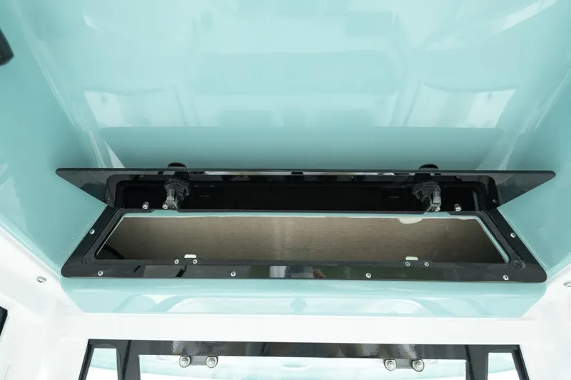 Slide: The Image of 2025 Sportsman Heritage 231 boat storage compartment with open lid, showcasing interior space. - 27