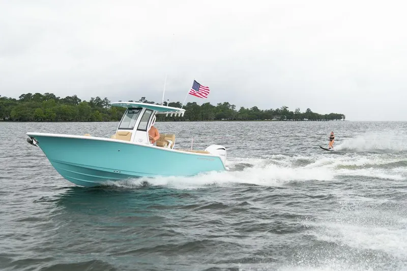 Slide: The Image of 2025 Sportsman Heritage 231 boat towing a water skier on a lake. - 3