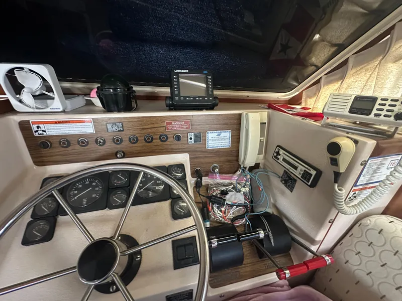Slide: The Image of 1989 Tollycraft 30 Sedan helm with steering wheel, gauges, and navigation equipment. - 14
