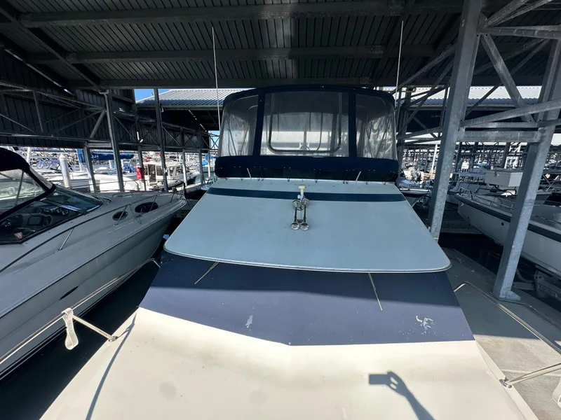 Slide: The Image of 1989 Tollycraft 30 Sedan boat docked in a covered marina. - 2