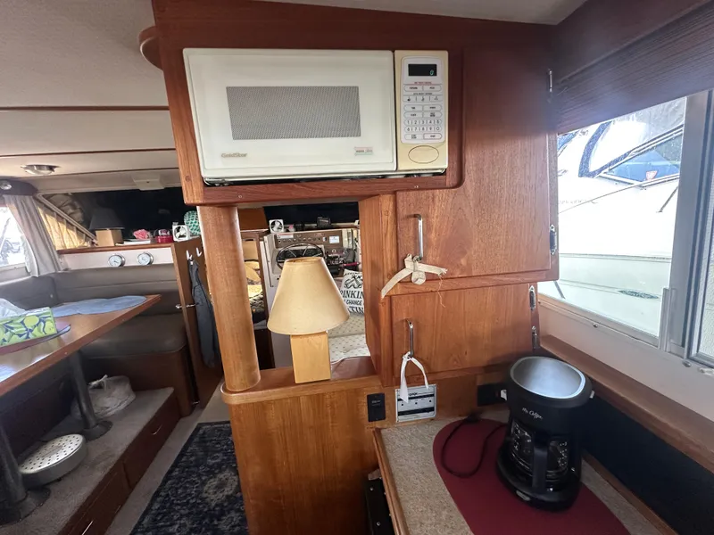 Slide: The Image of Interior of 1989 Tollycraft 30 Sedan with microwave, coffee maker, and wooden cabinetry. - 22
