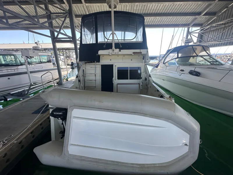 Slide: The Image of 1989 Tollycraft 30 Sedan docked with inflatable boat and Suzuki motor. - 3