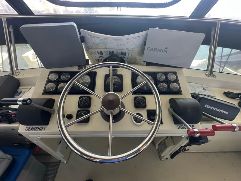 Slide: The Image of 1989 Tollycraft 30 Sedan helm with steering wheel, Garmin and Raymarine equipment. - 8