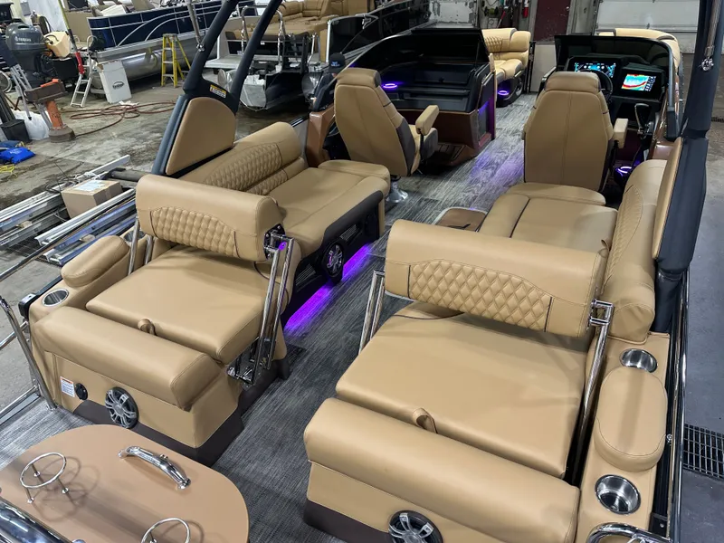 Slide: The Image of 2025 Tahoe Grand Tahoe 2585 Tritoon interior with luxurious tan seating and modern dashboard. - 30