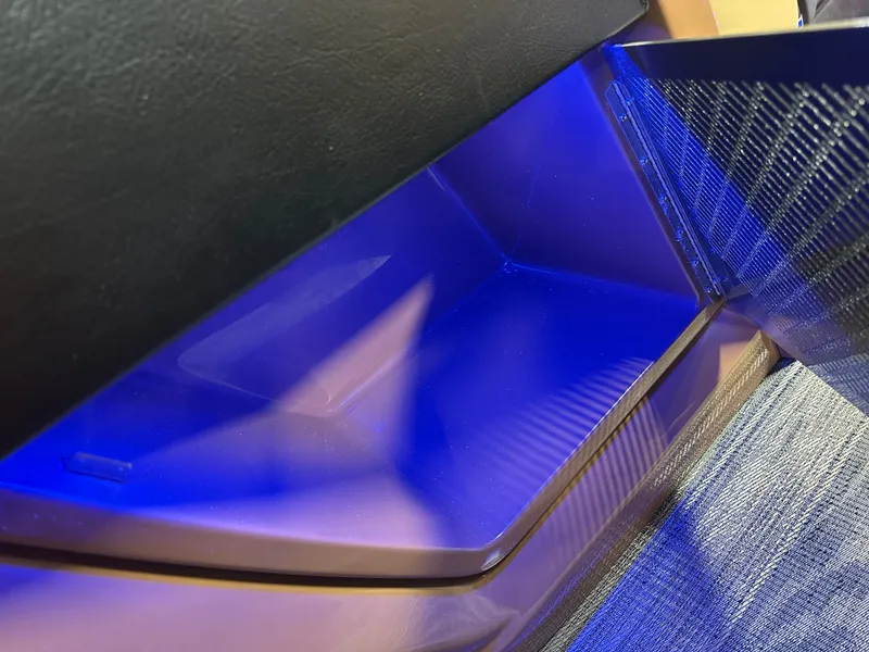 Slide: The Image of Interior storage compartment with blue LED lighting in 2025 Tahoe Grand Tahoe Tritoon. - 39