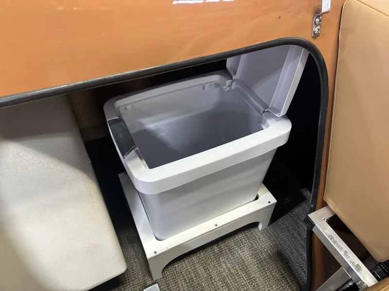 Slide: The Image of Storage compartment with a white bin inside a 2025 Tahoe Grand Tahoe 2585 Quad Lounge Tritoon. - 49