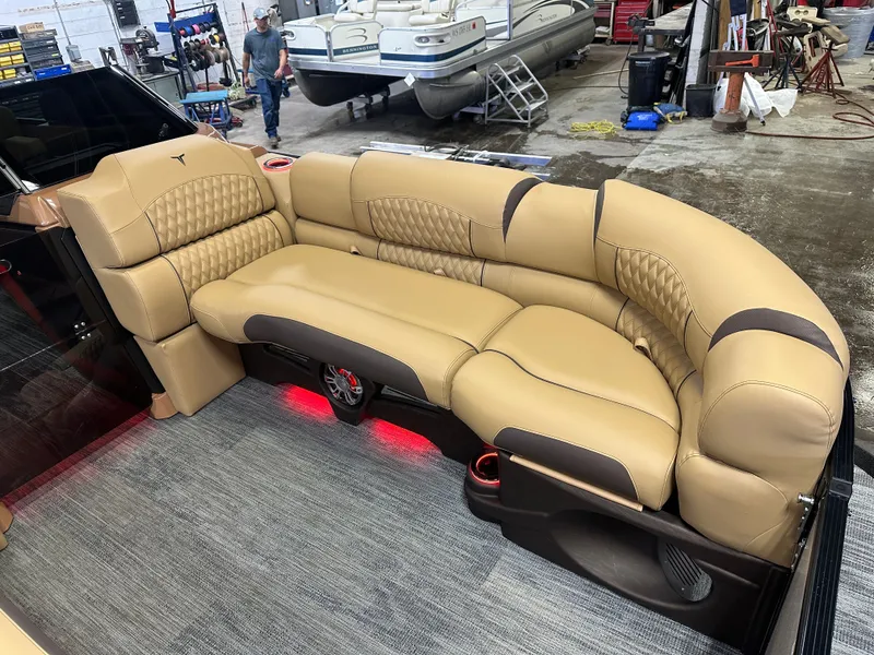 Slide: The Image of Luxurious seating in 2025 Tahoe Grand Tahoe 2585 Tritoon boat with tan upholstery and ambient lighting. - 9
