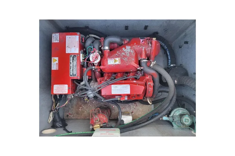 Slide: The Image of Engine compartment of a 2010 Intrepid 39 Kevlar Hull Sport Yacht, featuring red machinery and hoses. - 15