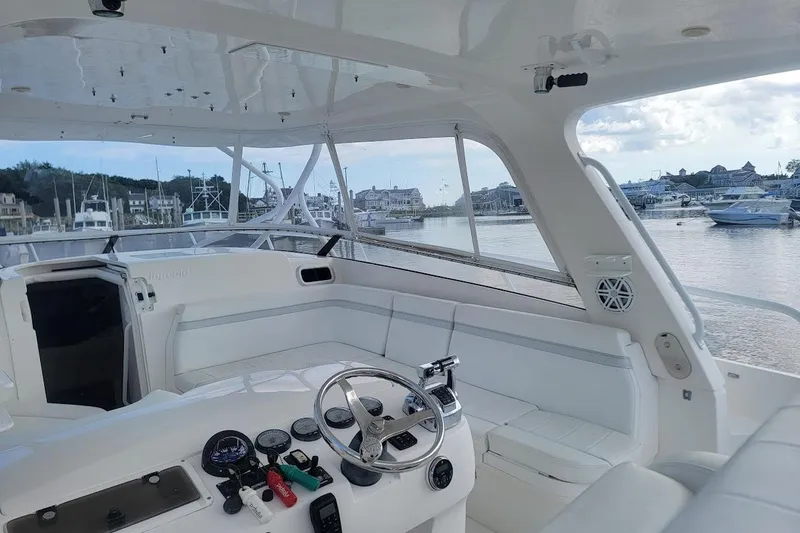 Slide: The Image of 2010 Intrepid 39 Kevlar Hull yacht interior with helm, white seating, and marina view. - 32