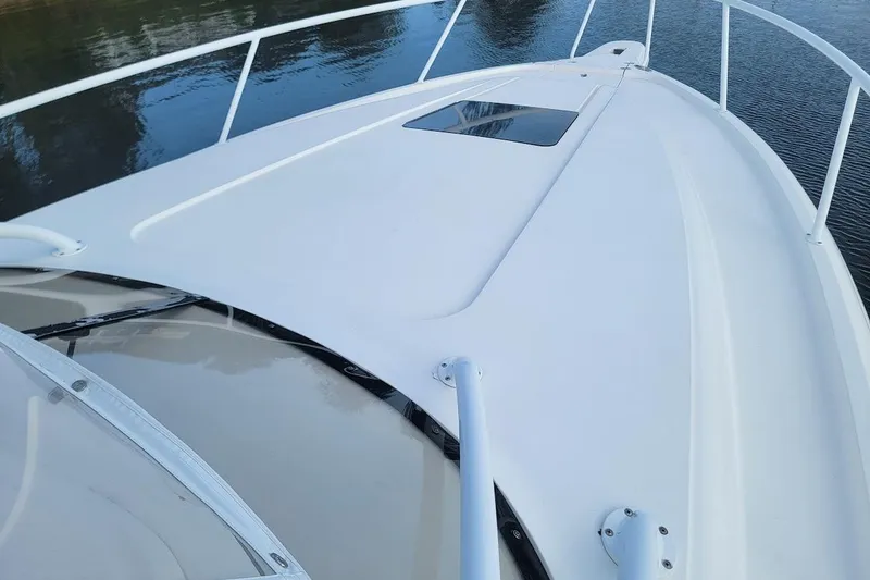 Slide: The Image of 2010 Intrepid 39 Kevlar Hull yacht deck, sleek design, white finish, calm water backdrop. - 33