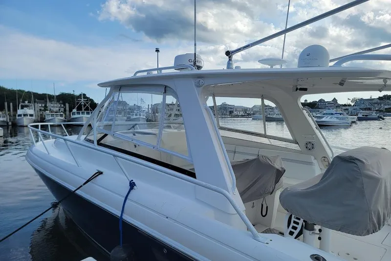 Slide: The Image of 2010 Intrepid 39 Kevlar Hull Sport Yacht docked at marina, featuring sleek design and covered seats. - 36