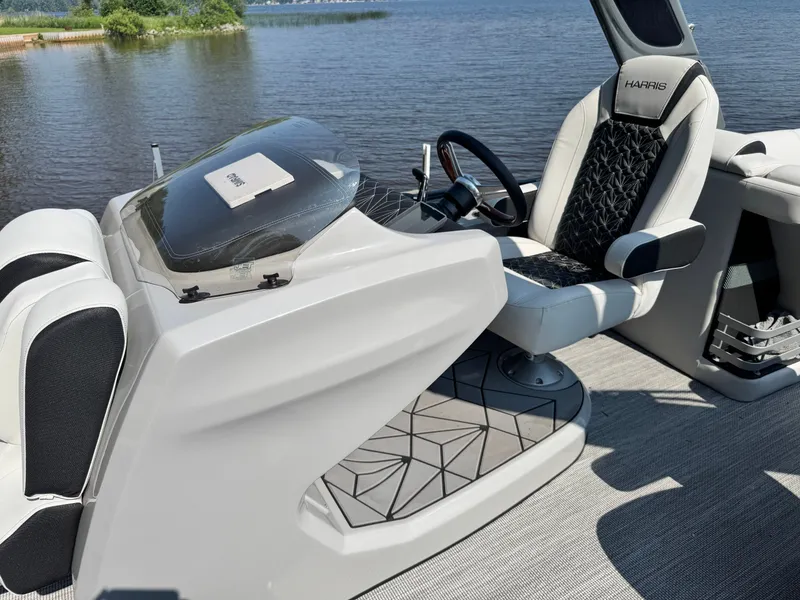 Slide: The Image of 2024 Harris 250 Grand Mariner boat interior with sleek captain's chair and steering console. - 11