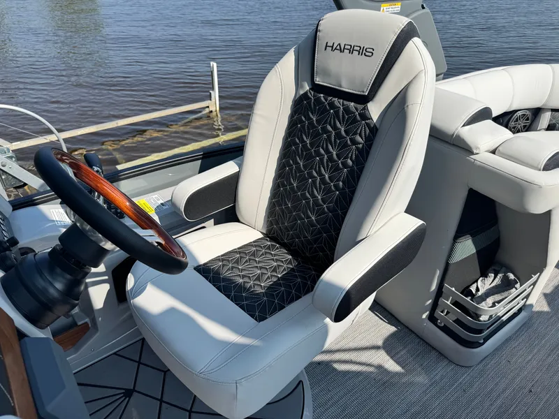 Slide: The Image of 2024 Harris 250 Grand Mariner captain's chair and steering wheel by the water. - 12