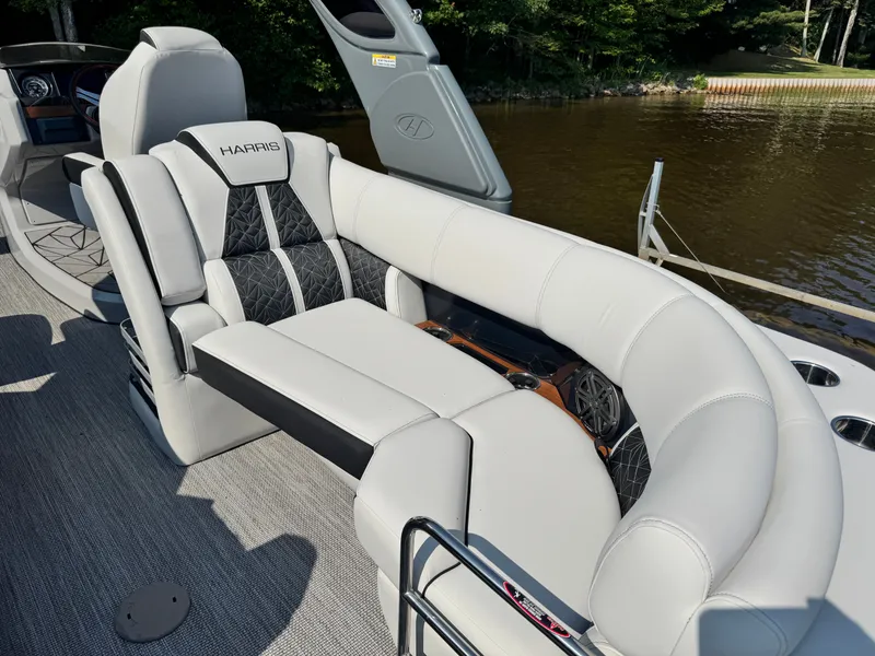 Slide: The Image of 2024 Harris 250 Grand Mariner boat interior with luxurious seating by the water. - 17