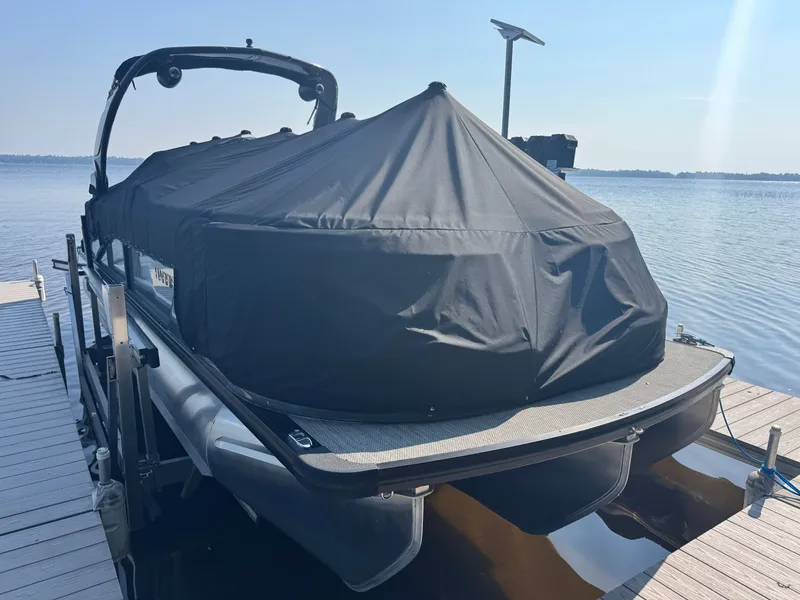 Slide: The Image of 2024 Harris 250 Grand Mariner pontoon boat covered at dockside. - 3
