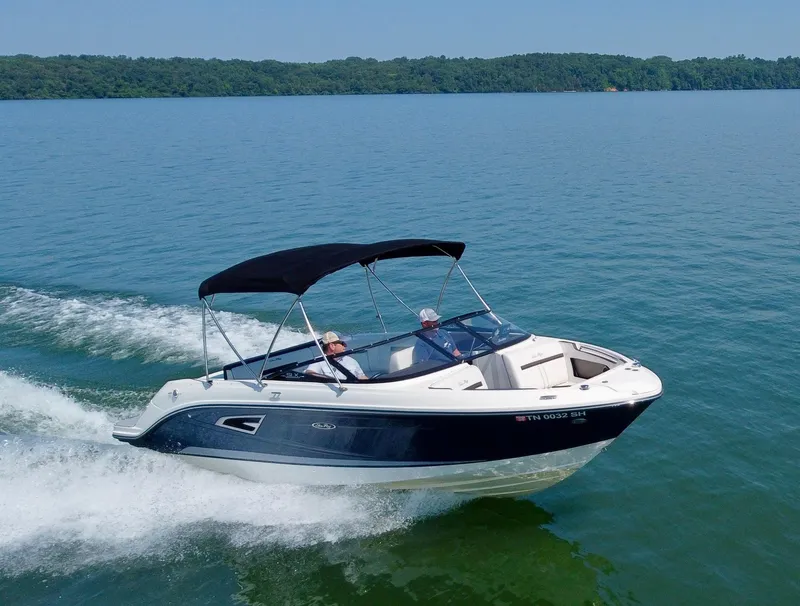 The Image of 2017 Sea Ray SLX 230 boat cruising on a lake with lush green shoreline. - 0