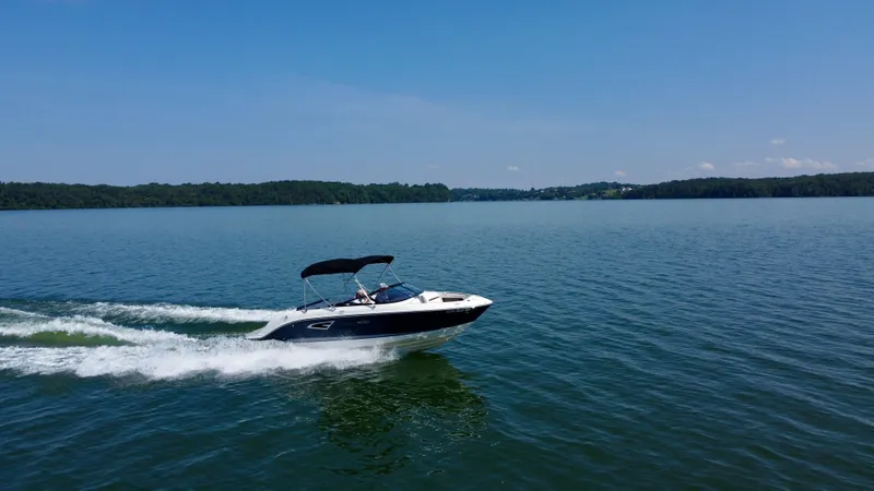 Slide: The Image of 2017 Sea Ray SLX 230 cruising on a serene lake under a clear blue sky. - 11