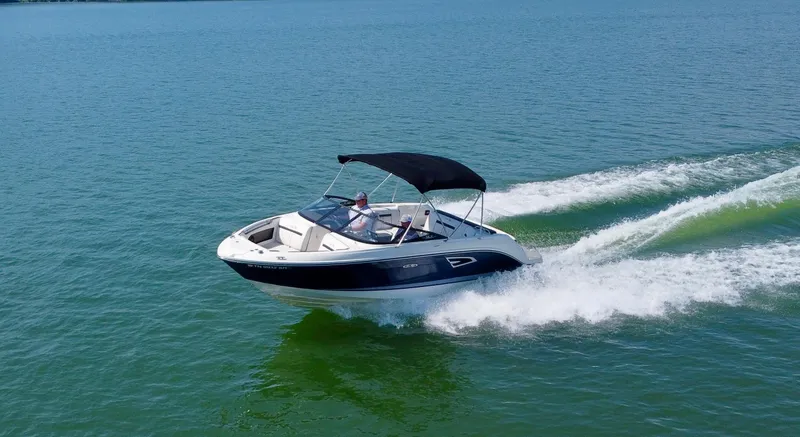 Slide: The Image of 2017 Sea Ray SLX 230 boat cruising on open water with a black canopy. - 12