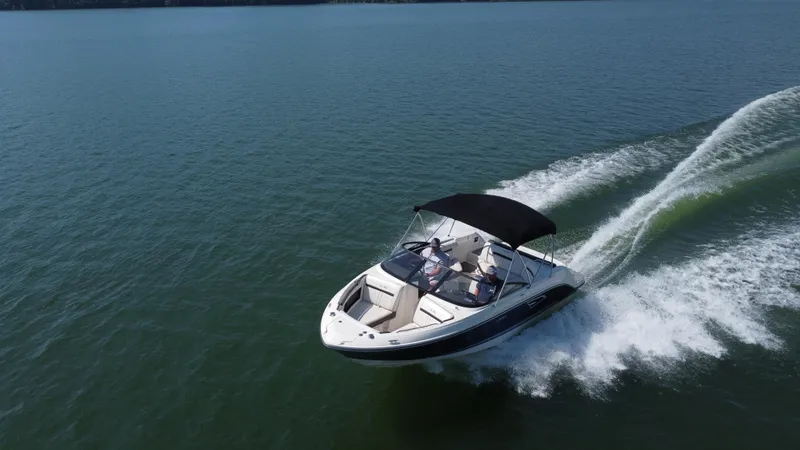 Slide: The Image of 2017 Sea Ray SLX 230 boat cruising on open water with a black canopy. - 14