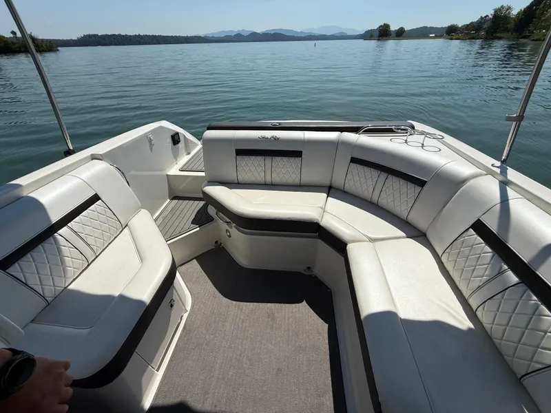 Slide: The Image of 2017 Sea Ray SLX 230 boat interior with white leather seating on a calm lake. - 15
