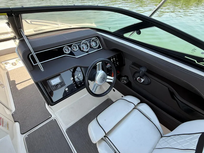 Slide: The Image of 2017 Sea Ray SLX 230 boat cockpit with steering wheel and control panel. - 17