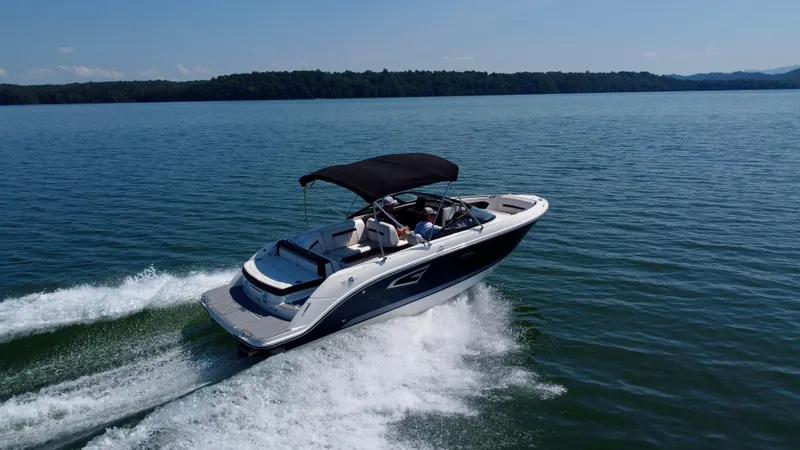 Slide: The Image of 2017 Sea Ray SLX 230 boat cruising on a serene lake under clear skies. - 3