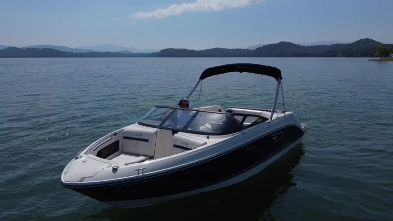 Slide: The Image of 2017 Sea Ray SLX 230 boat on a serene lake with distant hills. - 4