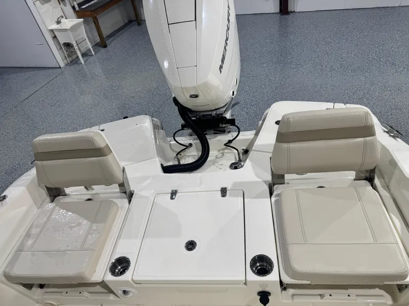 Slide: The Image of 2024 Boston Whaler 250 Dauntless boat interior with seating and table, parked in a marina. - 12