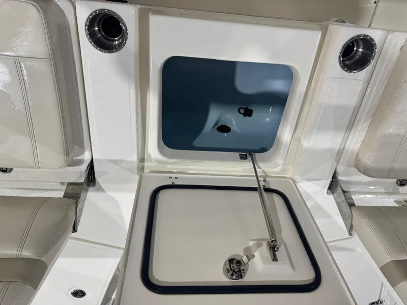 Slide: The Image of 2024 Boston Whaler 250 Dauntless boat interior with seating and table, parked outdoors. - 13