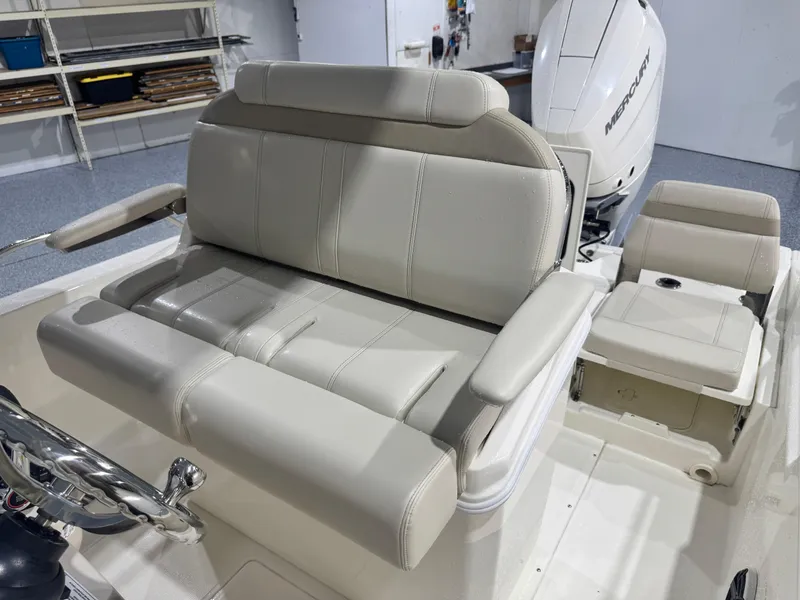 Slide: The Image of 2024 Boston Whaler 250 Dauntless boat seat with armrests, featuring sleek gray upholstery. - 16