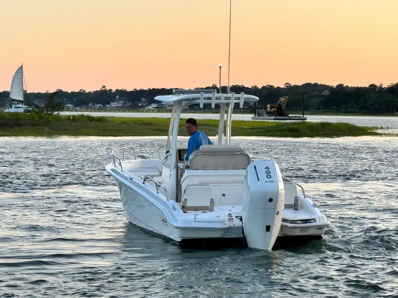 Slide: The Image of 2024 Boston Whaler 250 Dauntless boat cruising on a serene waterway at sunset. - 3