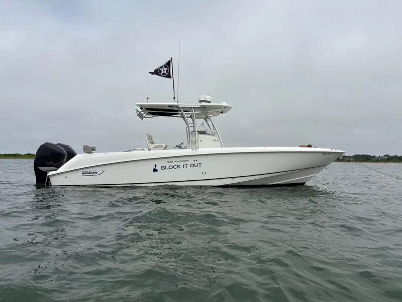 Slide: The Image of 2005 Boston Whaler 320 Outrage boat on water, side view with flag. - 12