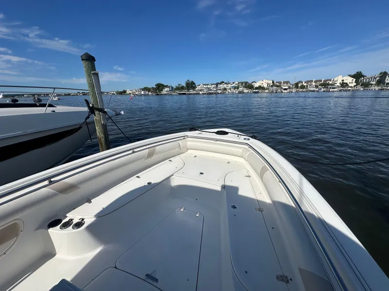 Slide: The Image of 2005 Boston Whaler 320 Outrage boat docked in a marina under clear blue skies. - 14