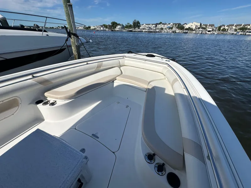 Slide: The Image of 2005 Boston Whaler 320 Outrage boat interior with seating, docked by calm waters. - 17
