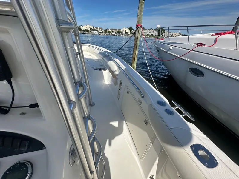 Slide: The Image of 2005 Boston Whaler 320 Outrage docked, showcasing sleek design and spacious deck. - 22