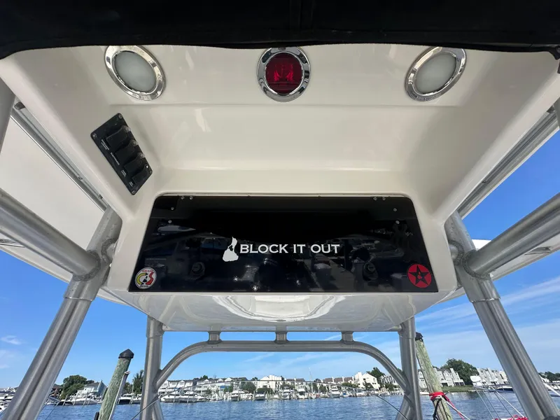 Slide: The Image of 2005 Boston Whaler 320 Outrage boat console with "Block It Out" decal, dockside view. - 23